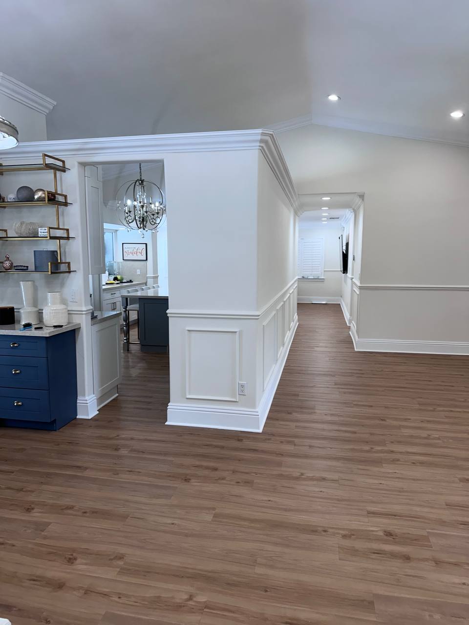 Renovated living area with decorative millwork and wood-look flooring